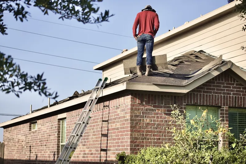 Professional roofer working on a residential roof in Virginville